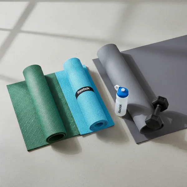 Various Reebok yoga mats displayed, showing different thicknesses, colors, and textures for diverse fitness needs.
